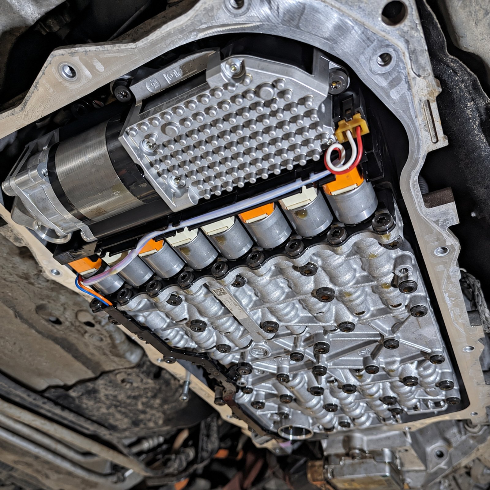 Exposed automatic transmission mechatronic unit viewed from underneath a BMW vehicle.