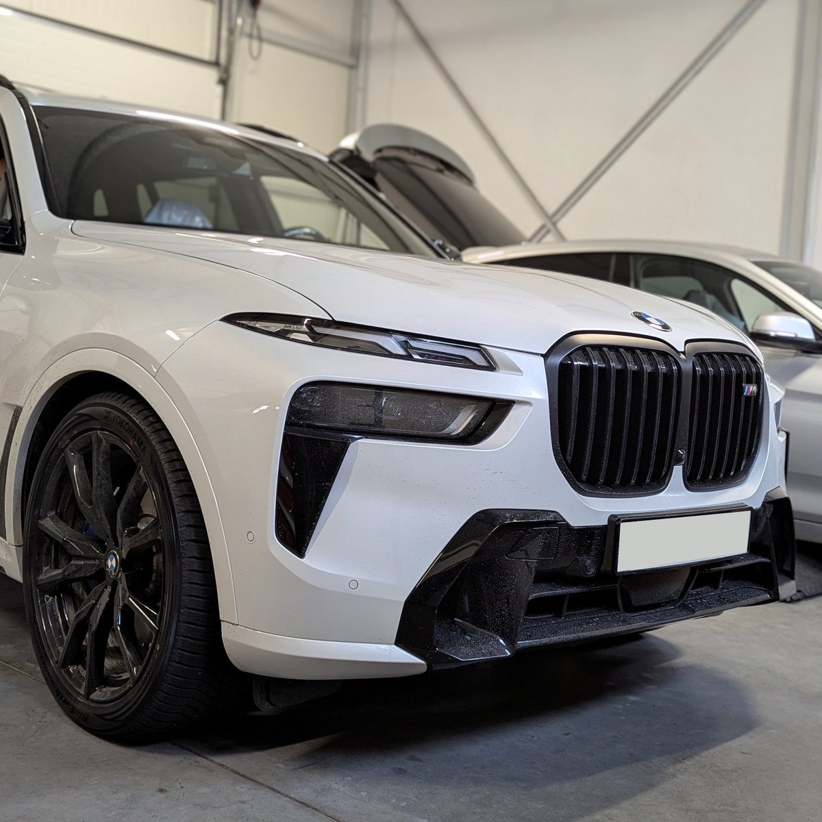 Białe BMW X7 G07 LCI w warsztacie BavELab, widok z przodu